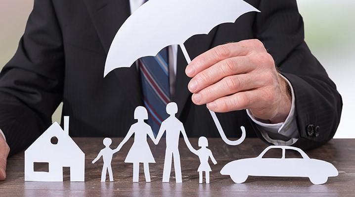 Person holding house car and people paper cut outs
