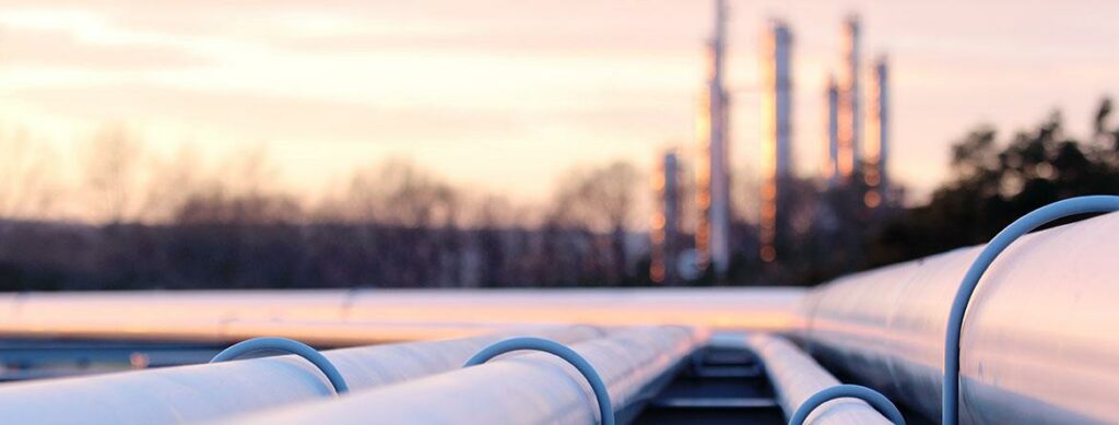 Pipes stretch into the distance under a pastel sky