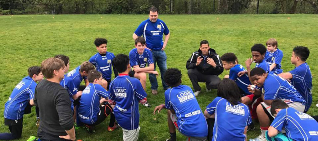 Soccer team kneels around coach