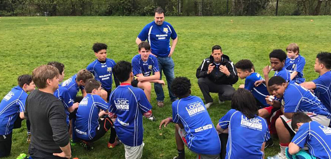 Soccer team kneels around coach