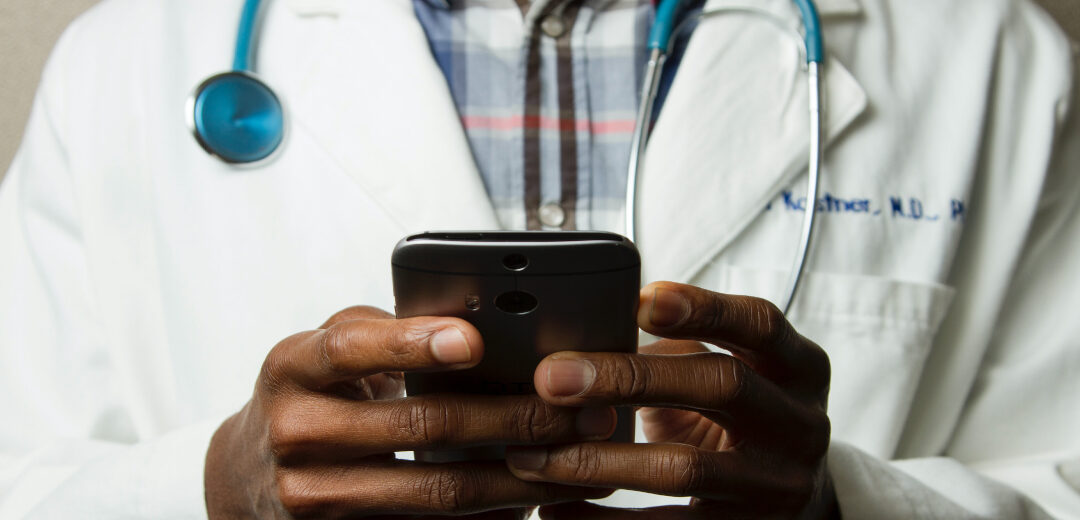 Doctor typing on phone