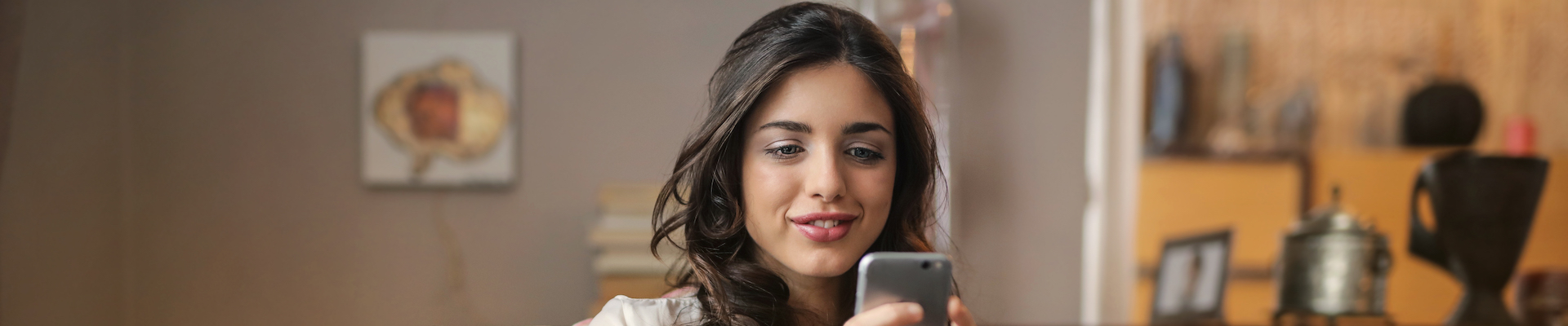woman sitting on sofa using smartphone
