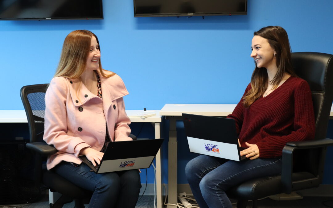 Two Logic20/20 teammates conversing in an office setting