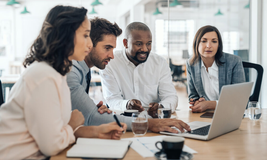 business team gathered around a laptop computer