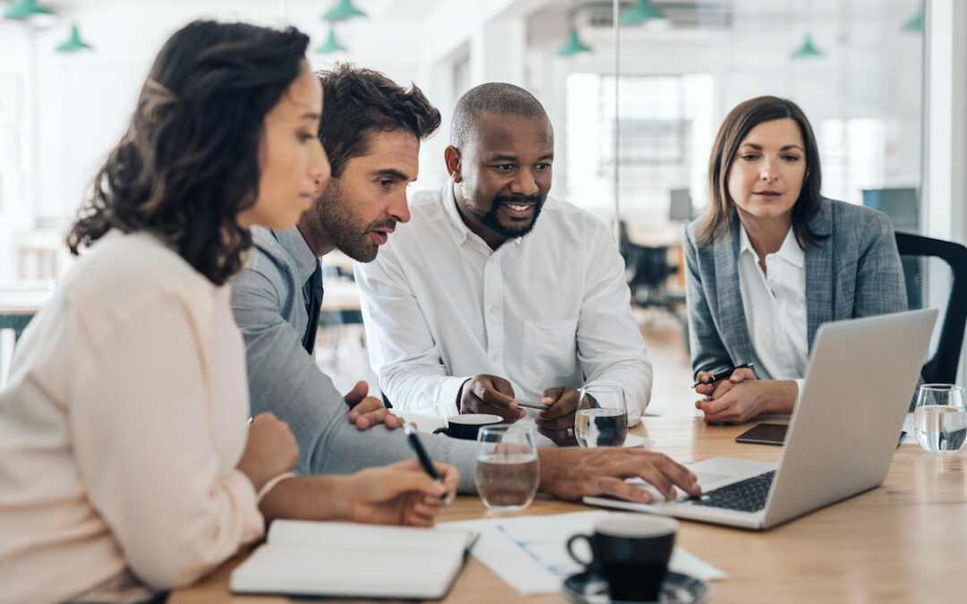business team gathered around a laptop computer