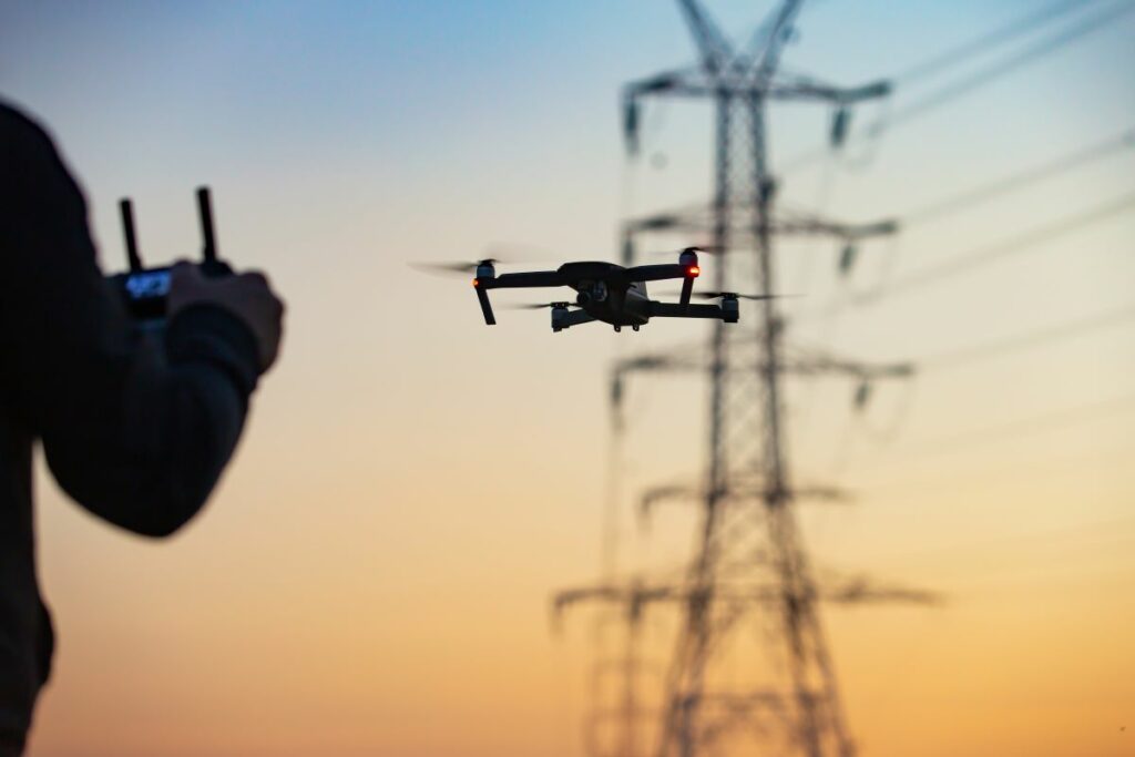 utility worker flying a drone near power lines