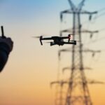 utility worker flying a drone near power lines