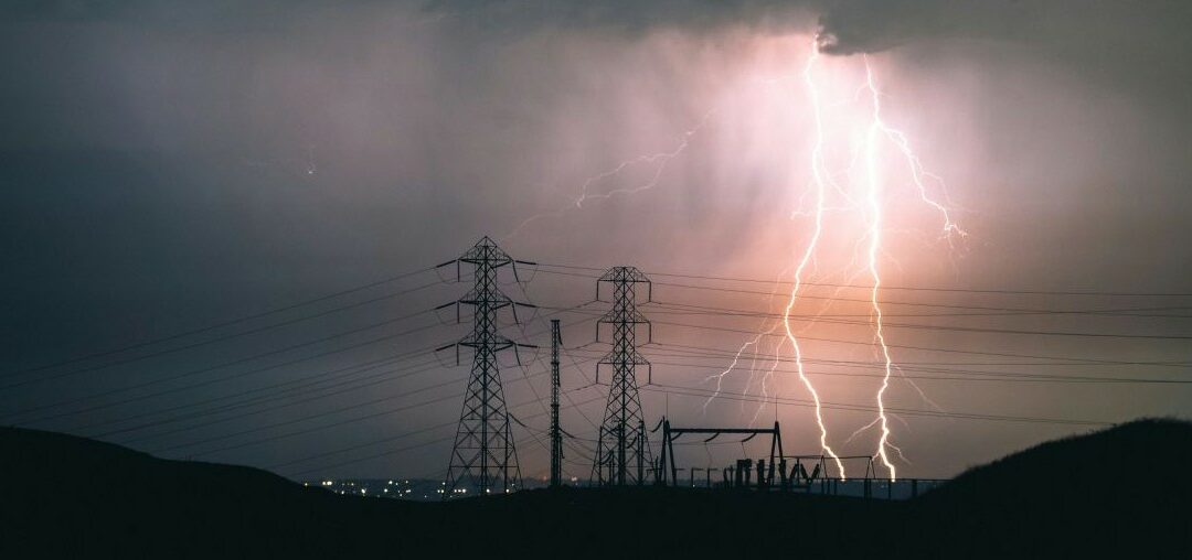 electricity distribution towers against the background of a lightning storm