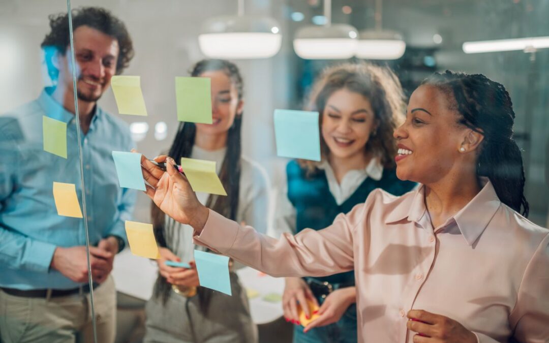 Business team brainstorming and planning using sticky notes on glass wall