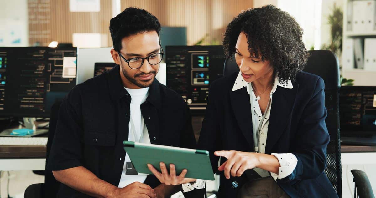office workers collaborate around a tablet screen