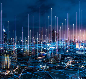 5g_utility_grid_of_the_future_small people at a desk reviewing an analytics dashboard